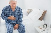 pic of watch  - Elderly man suffering with belly pain in the bedroom - JPG 