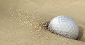 picture of golf  - An extreme close up of a golf ball hitting the sand in a bunker and emitting grains of sand forwards - JPG 