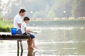 stock photo of bridge  - Man and boy fishing on the lake - JPG 