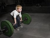 picture of boy  - Determined Young Boy trying to lift Heavy weights - JPG 