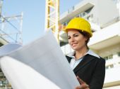 foto of construction  - female engineer looking at blueprints in construction site - JPG 