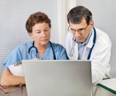 image of medical doctors  - Doctor And Nurse Talking and Working at Laptop Computer In Office - JPG 