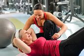 foto of fitness  - Fitness center senior woman exercise with personal trainer on mat - JPG 
