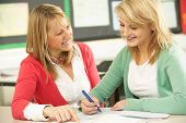 stock photo of study  - Female Teenage Student Studying In Classroom With Teacher - JPG 