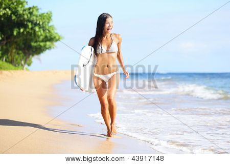 Picture or Photo of Beach woman fun with body surfboard. Happy beautiful bikini model running on beach looking at the sea on summer vacation holidays. Mixed race Asian / Caucasian woman on Kaanapali beach, Maui, Hawaii.