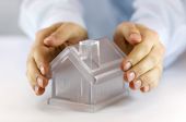 picture of security  - Hands covering a glass model home over white background - JPG 
