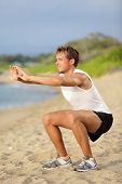 foto of fitness  - Fitness man training air squat exercise on beach outside - JPG 