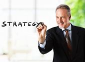 picture of strategy  - Businessman writing the word strategy on the screen - JPG 