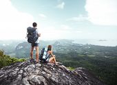 pic of valley  - Hikers with backpacks standing on top of a mountain and enjoying a valley view - JPG 