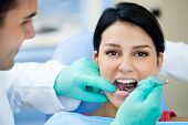 stock photo of watch  - Female patient having her teeth examined by dental specialist - JPG 